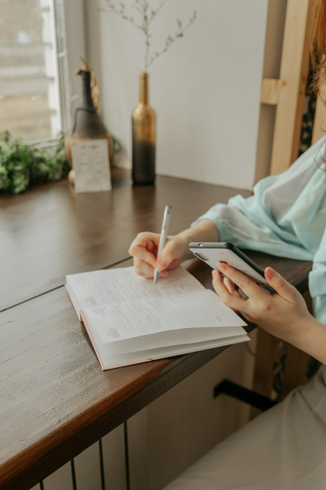woman tracking expenses in notebook